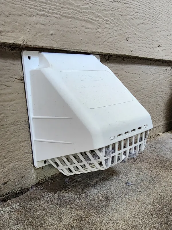 White exterior wall-mounted light/floodlight with a protective curved grille near ground.
